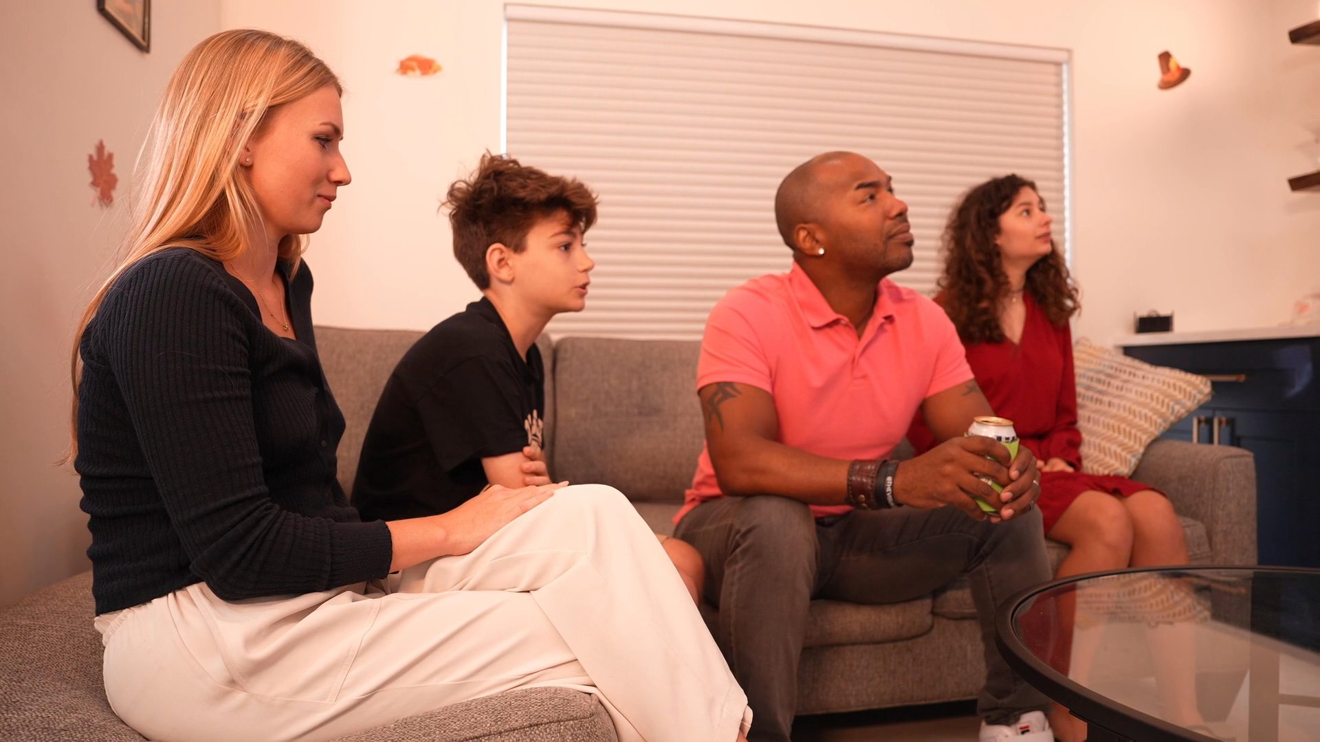 A family sits together in a living room, engaged in conversation while relaxing in a domestic setting.
