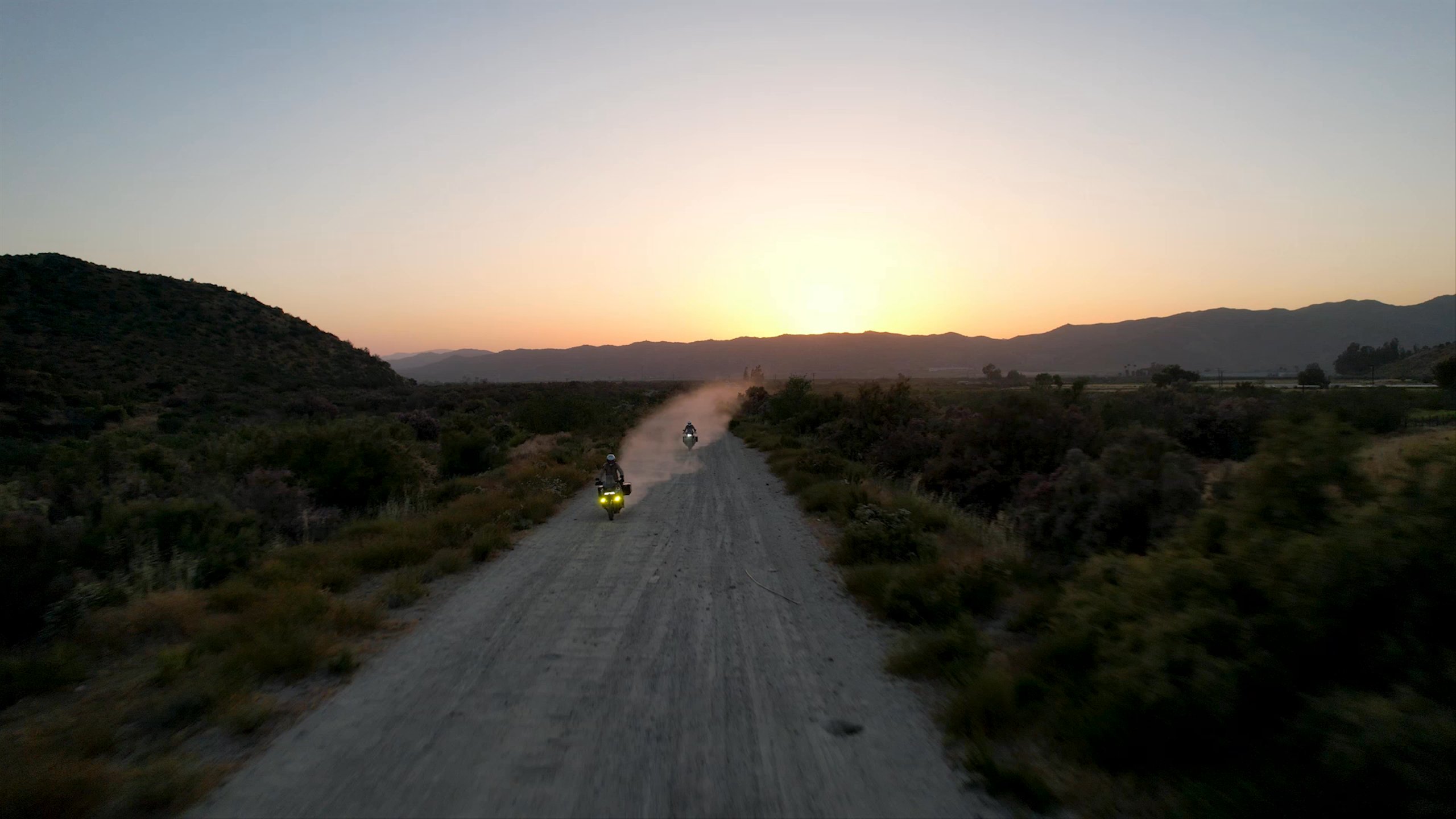 Video of motorcyclists riding down dirt road at sunset in Baja California