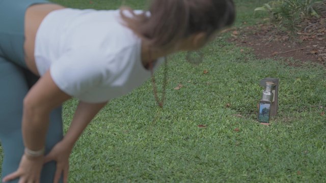 A woman recording a yoga practice session with her smartphone