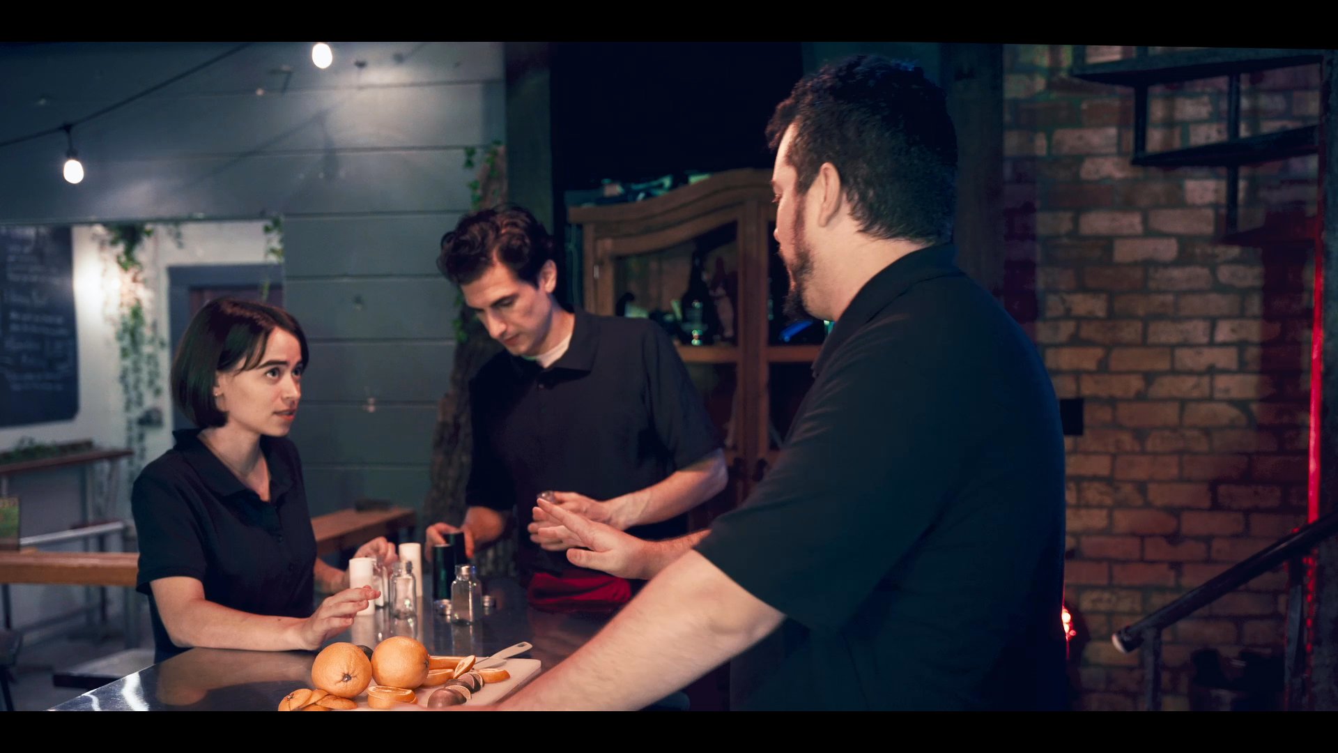 Professional bartenders collaborate behind a service bar to prepare drinks, demonstrating teamwork and refined service techniques. The scene shifts to individual staff members focusing on cocktail preparation at a table setting.