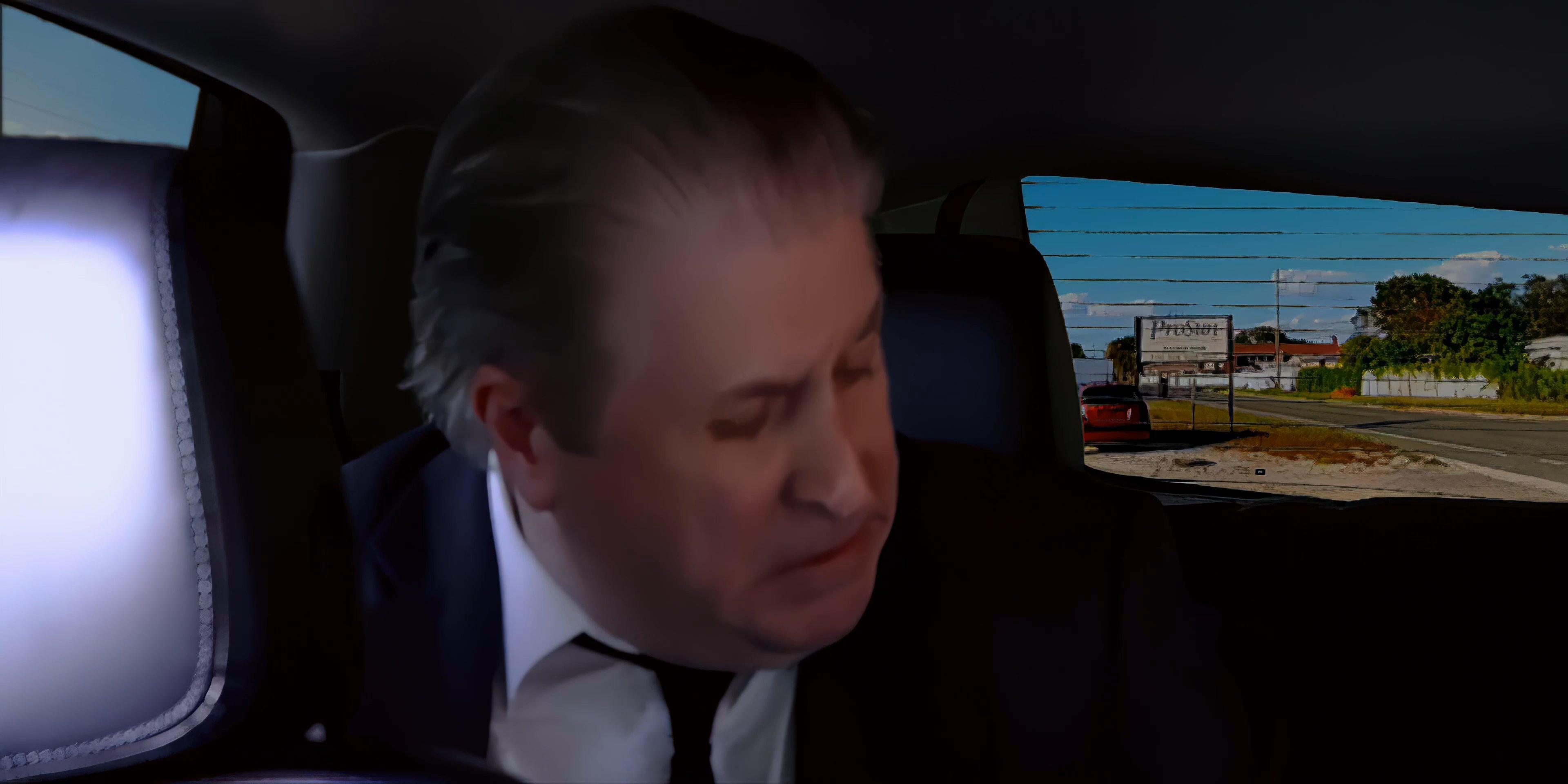 Two men engage in a serious conversation while seated in the back of a moving vehicle. The exchange involves attentive listening and spoken dialogue throughout the transit.