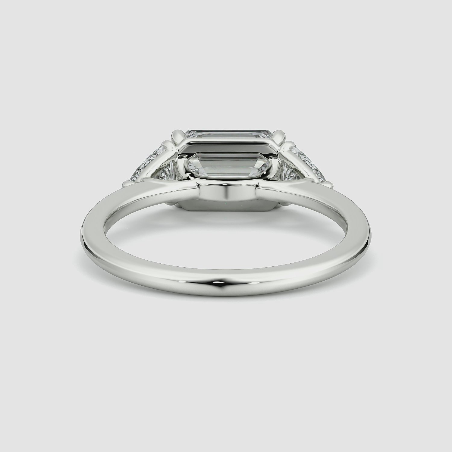 The Three Stone | Emerald | 18k | White Gold | bandAccent: Plain | diamondOrientation: horizontal | sideStoneCarat: 0.25ct | sideStoneShape: Trillion | caratWeight: other