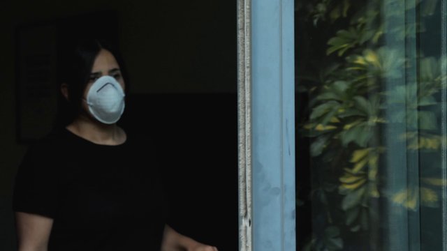 Woman wearing a mask near balcony 