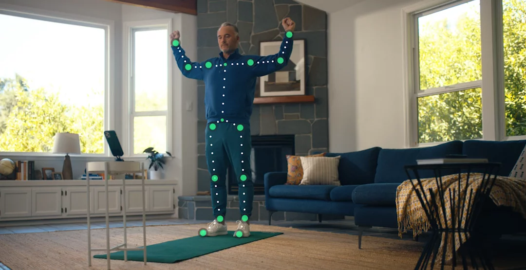 A man is doing a guided exercise in his living room while the Hinge Health app is tracking and correcting his movements in real time.