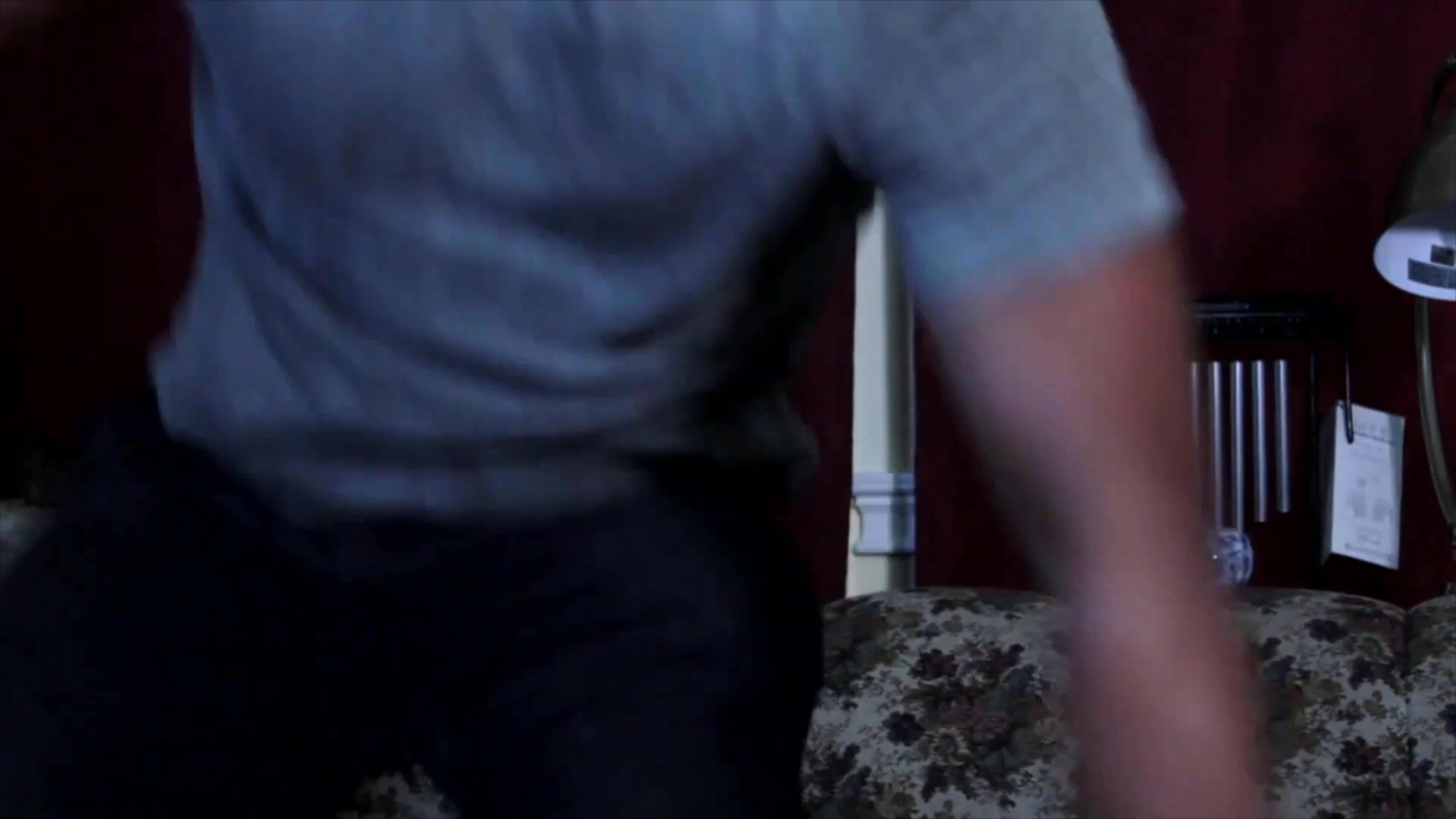 Two men engage in a tense verbal confrontation within a living room, leading to a physical departure. The scene captures heightened interpersonal friction and a dramatic shift in the atmosphere.