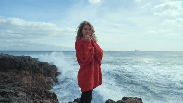 A beautiful girl standing on the rocky coast