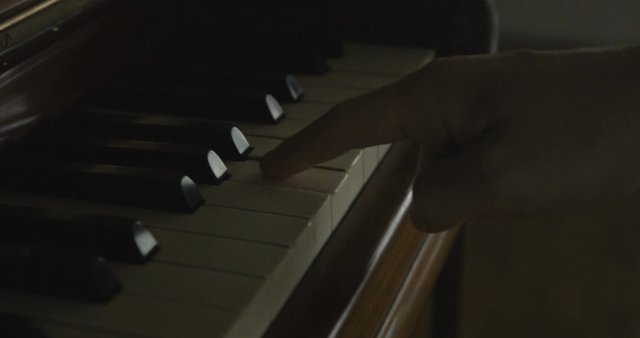 A finger moving over piano keys