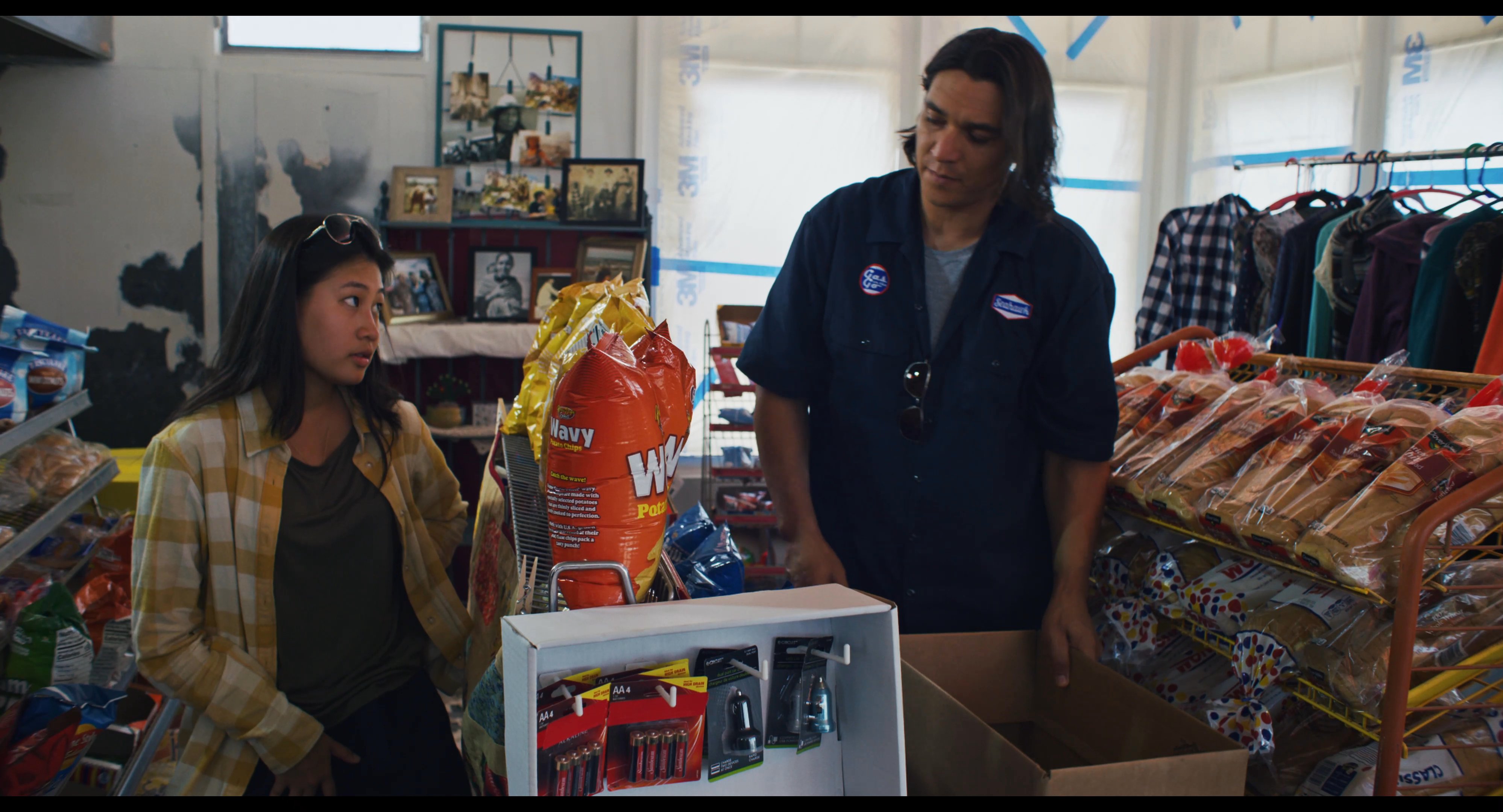 Two employees work together to organize and restock store merchandise within a retail environment.