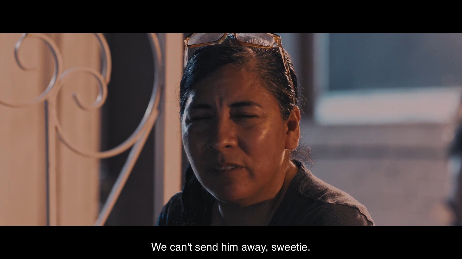 Two women engage in an intimate conversation on a porch about their commitment to caring for an aging family member. The dialogue reflects deep loyalty and emotional resolve regarding the responsibilities of domestic care.