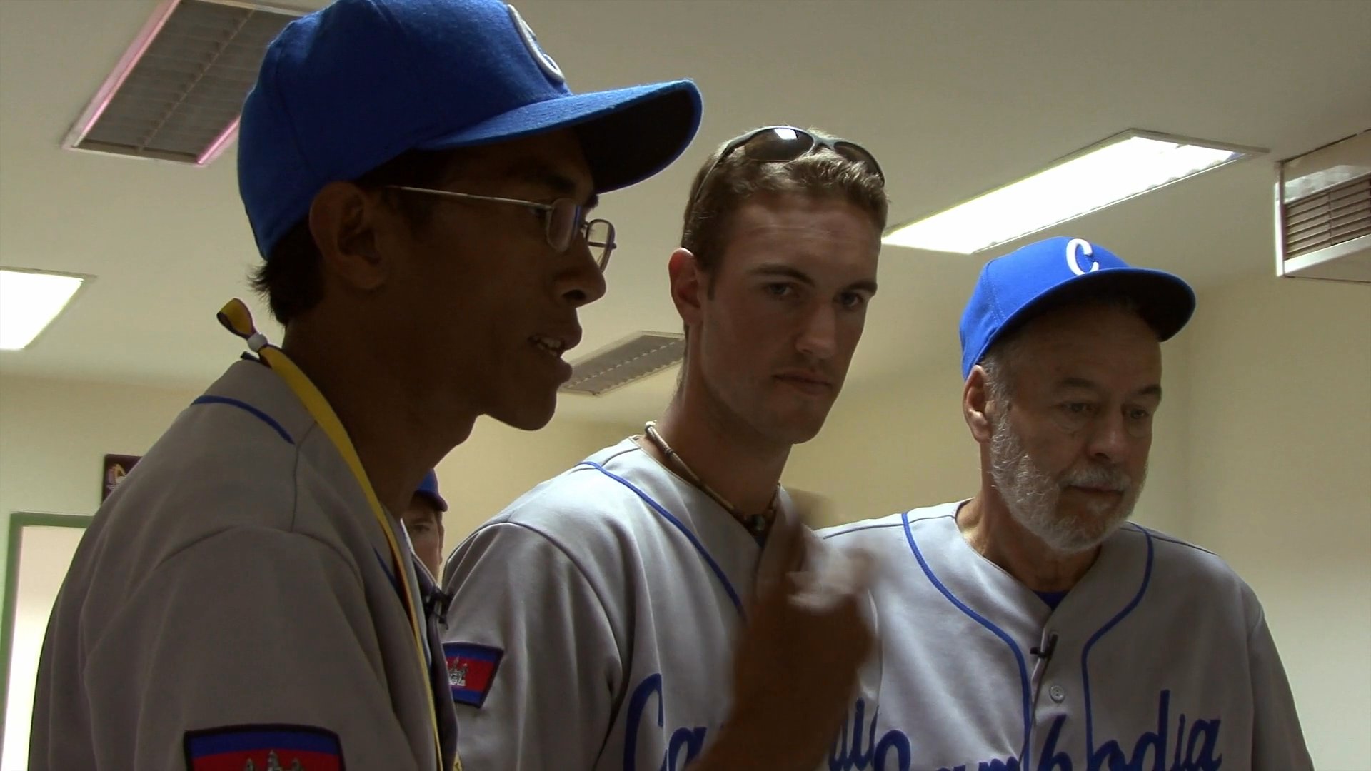 Members of a baseball team convene in a locker room to discuss tactical strategy and receive guidance from their coaching staff.