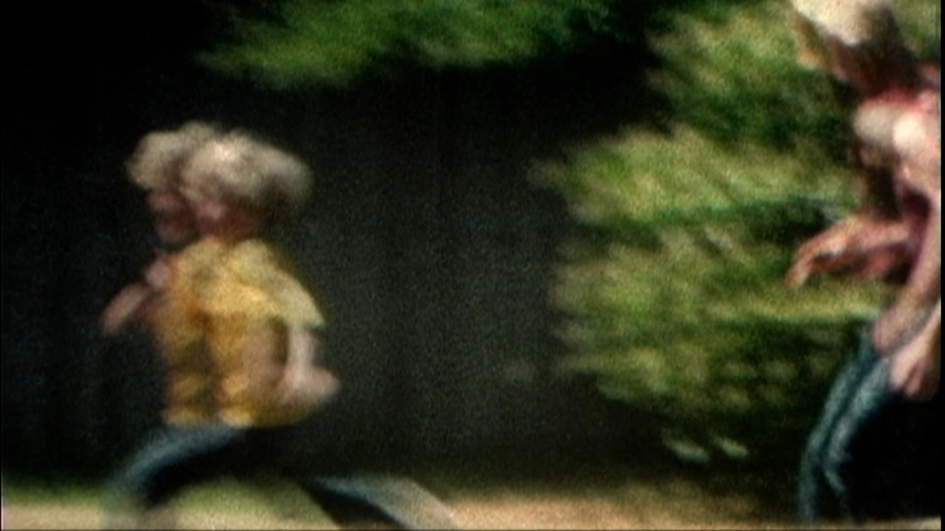 A long-bearded violinist performs while interspersed footage shows a child playing on a beach and a family member carrying a young boy through a backyard garden.