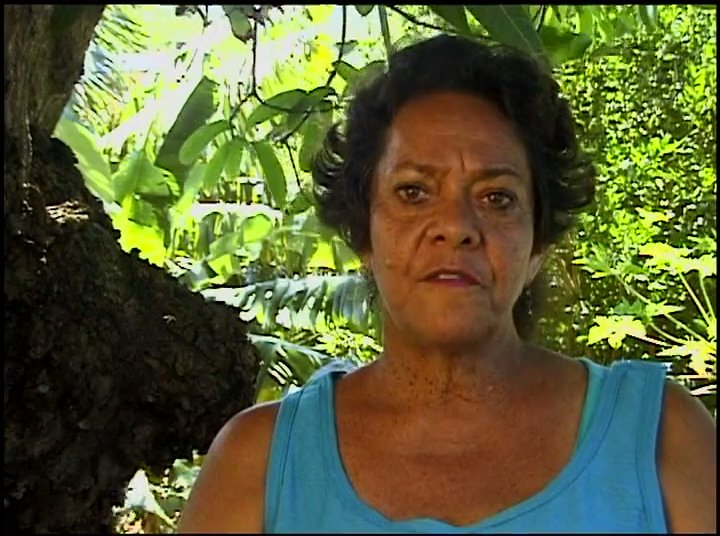 Anona Napoleon shares cultural insights against a backdrop of professional surfing and historical footage of island life. The narrative bridges contemporary ocean activities with traditional heritage.