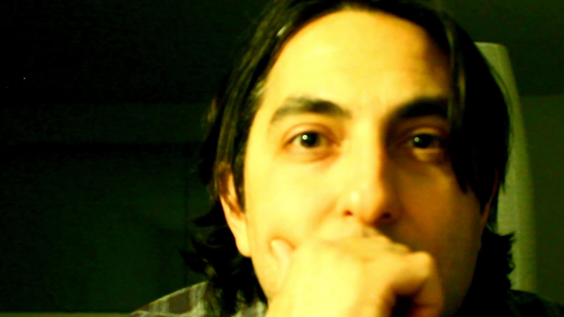 A man engages in a thoughtful monologue, utilizing hand gestures to emphasize his points during a direct-to-camera presentation.