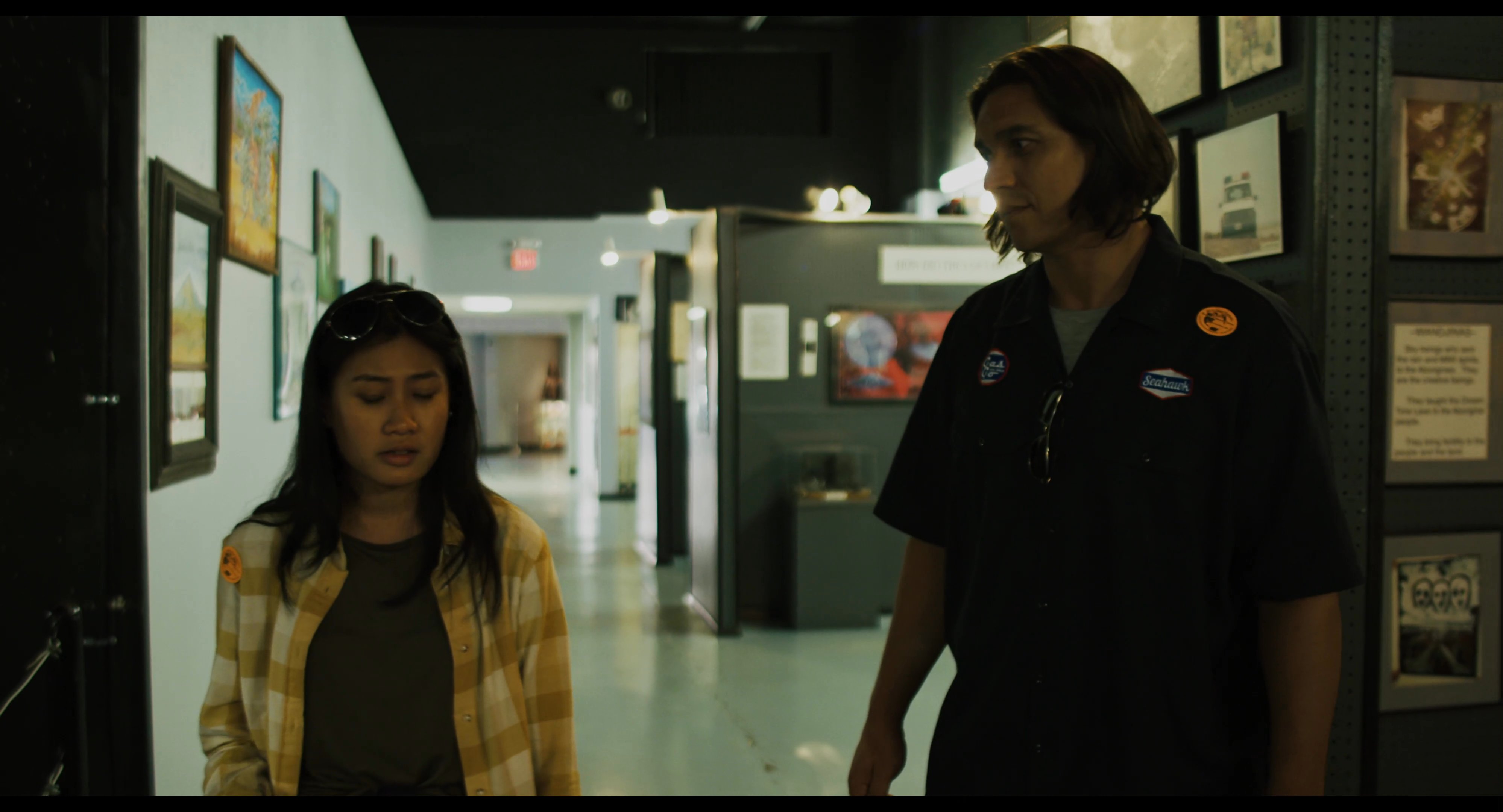 Two individuals engage in conversation while walking through a museum dedicated to extraterrestrial exhibits and UFO history.