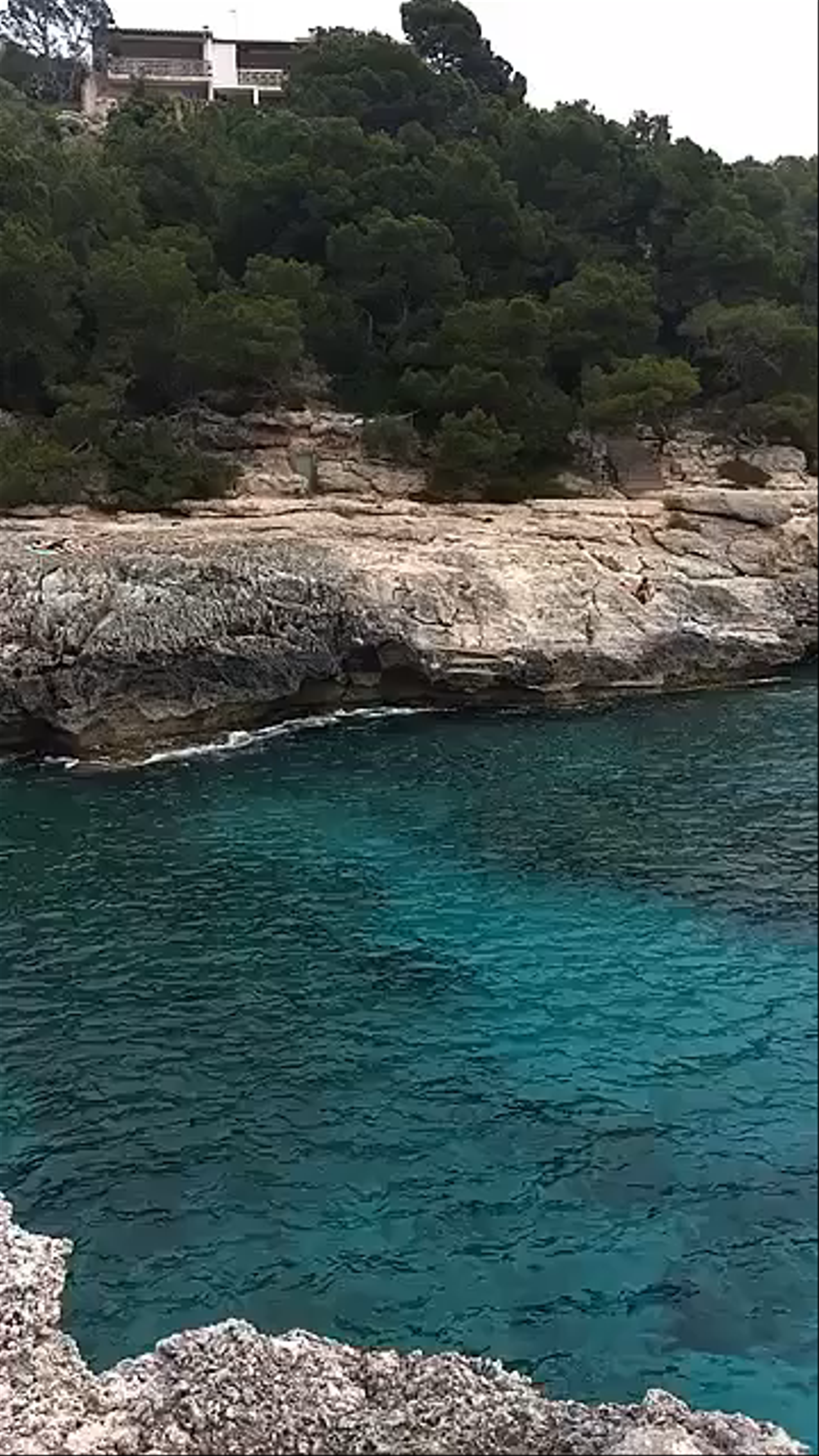 Crystal Clear Waters and Rugged Cliffs at Cala s'Almunia, Spain