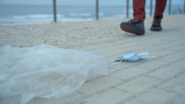 A man cleaning up a sidewalk by the beach