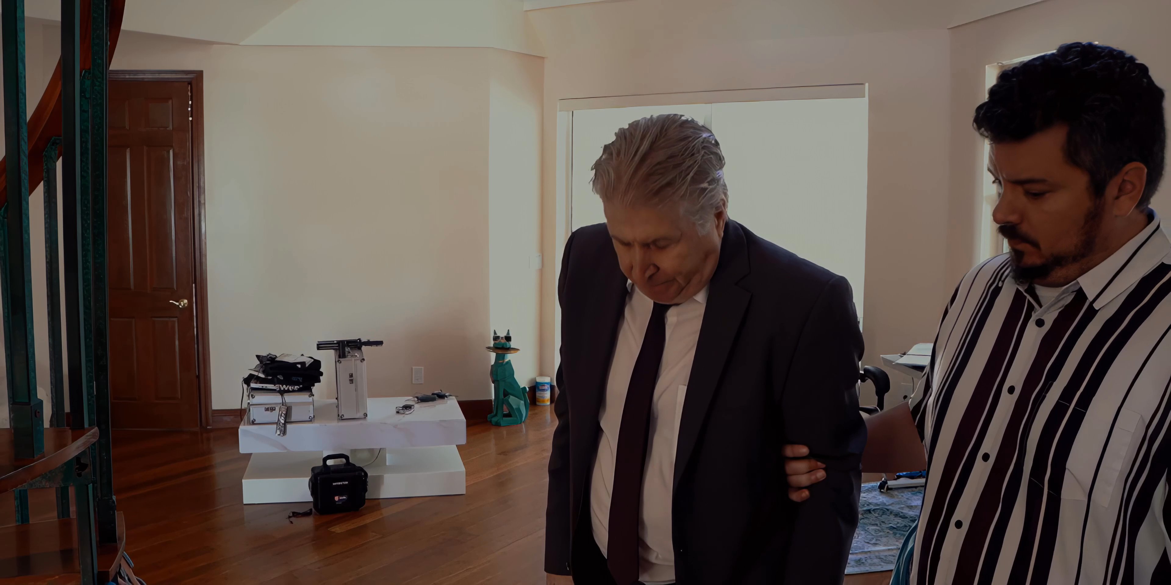 Three men engage in a tense physical and verbal confrontation inside a residence before two individuals exit the premises. The interaction displays clear interpersonal friction and a rapid transition from a structured meeting to a hasty departure.