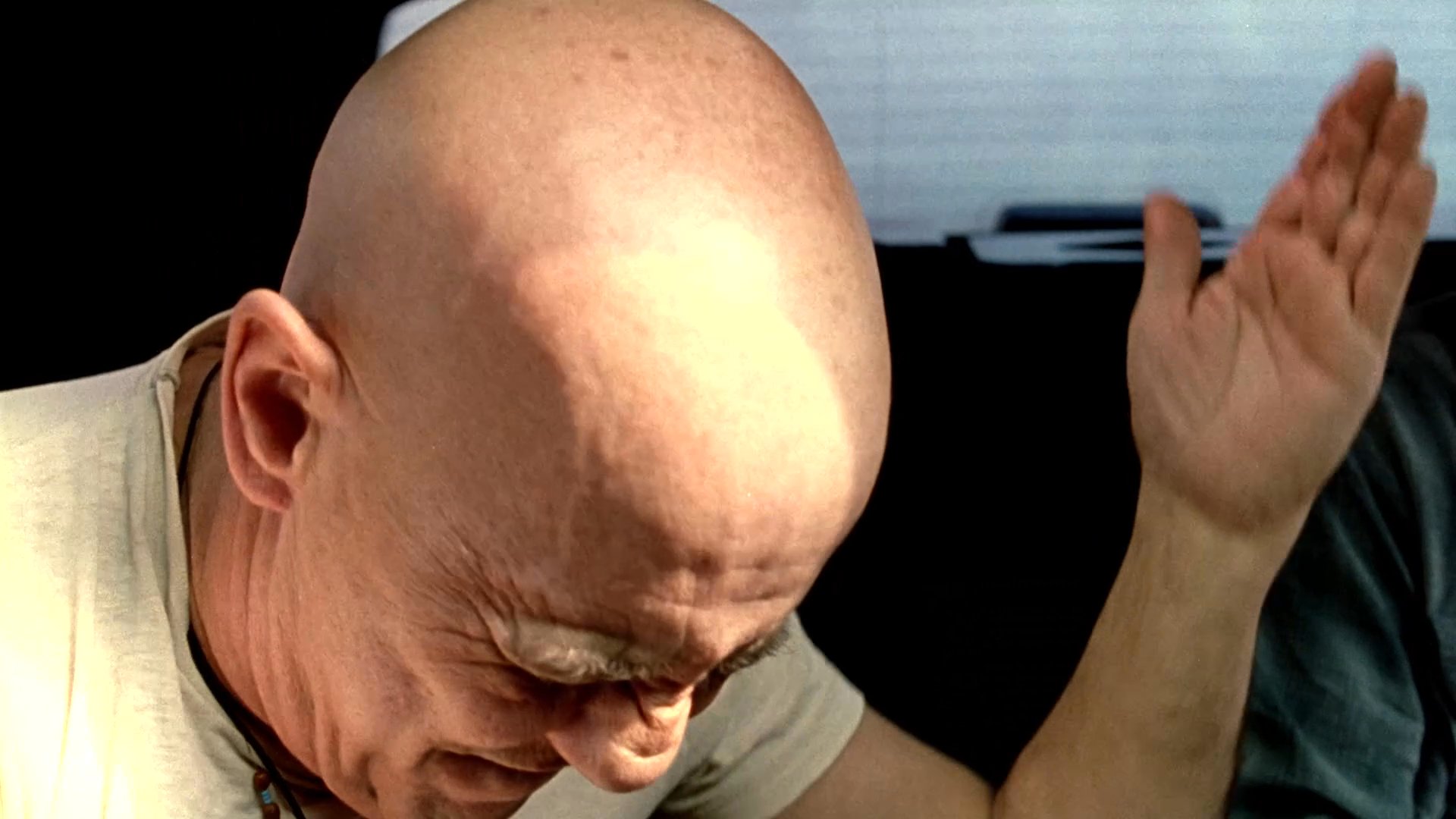 Three individuals engage in a heated, emotionally charged verbal disagreement while seated inside the back of a moving vehicle. The conversation escalates as the participants express frustration through intense gestures and facial expressions.