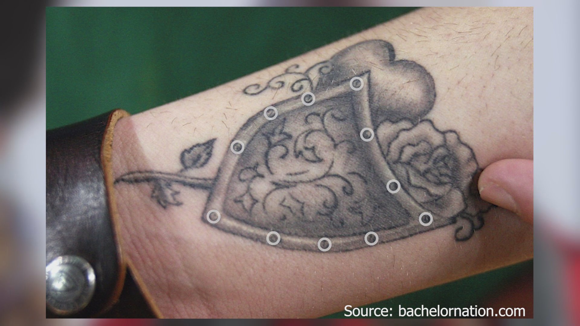 A close-up view of a shield-themed tattoo is enhanced with digital tracking points to map the design area.