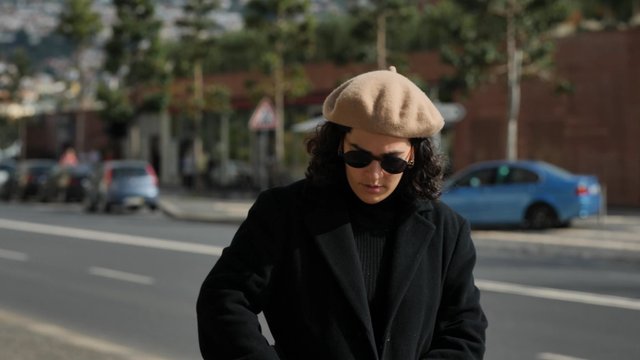 A woman films a video with her smartphone on the street