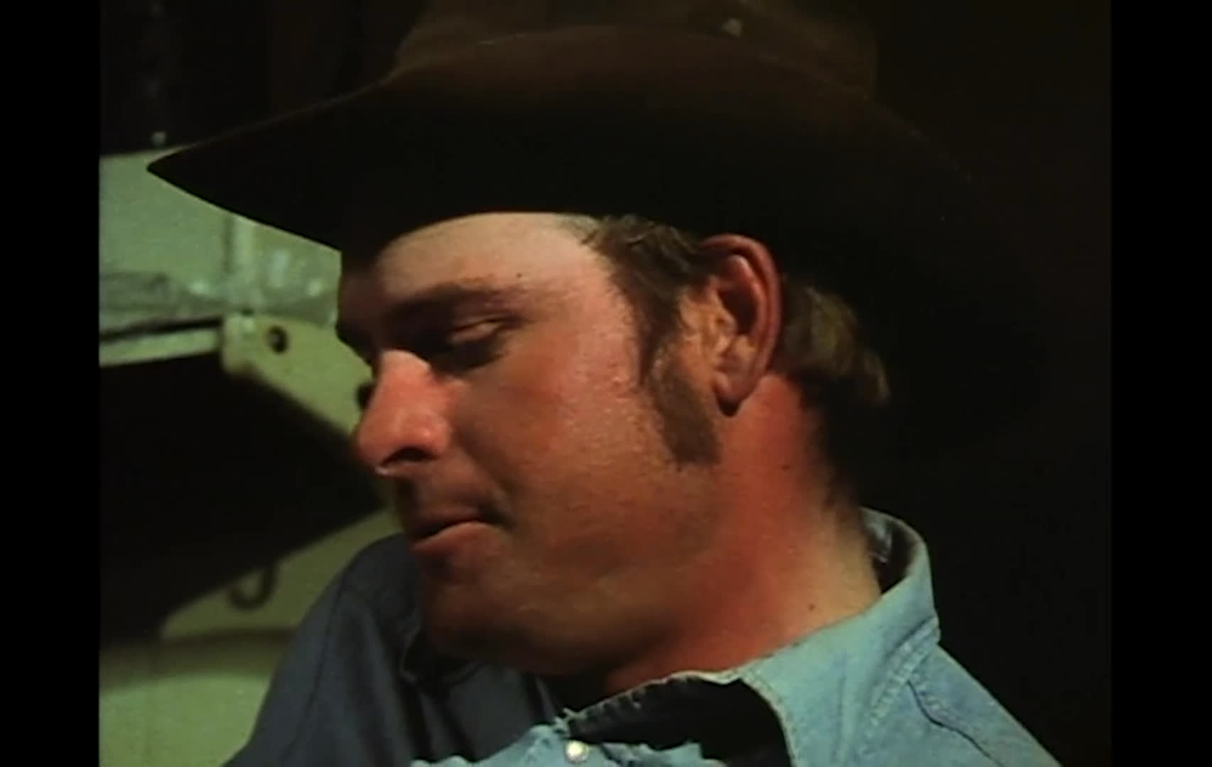 Ranchers and cowboys speak in a series of interview-style shots, discussing how a Bureau of Land Management proposal could affect small operators’ ability to secure pastureland. The conversation unfolds amid rustic interiors and western workwear, contrasting independent ranchers with larger outfits.