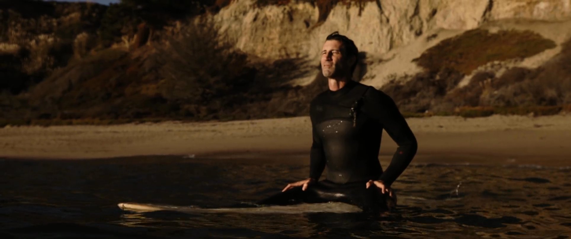 A man transitions from a rural setting with his horse to the coast to surf, reflecting on his journey while preparing his equipment. The narrative highlights a shift from rugged inland life to the tranquil environment of the ocean.