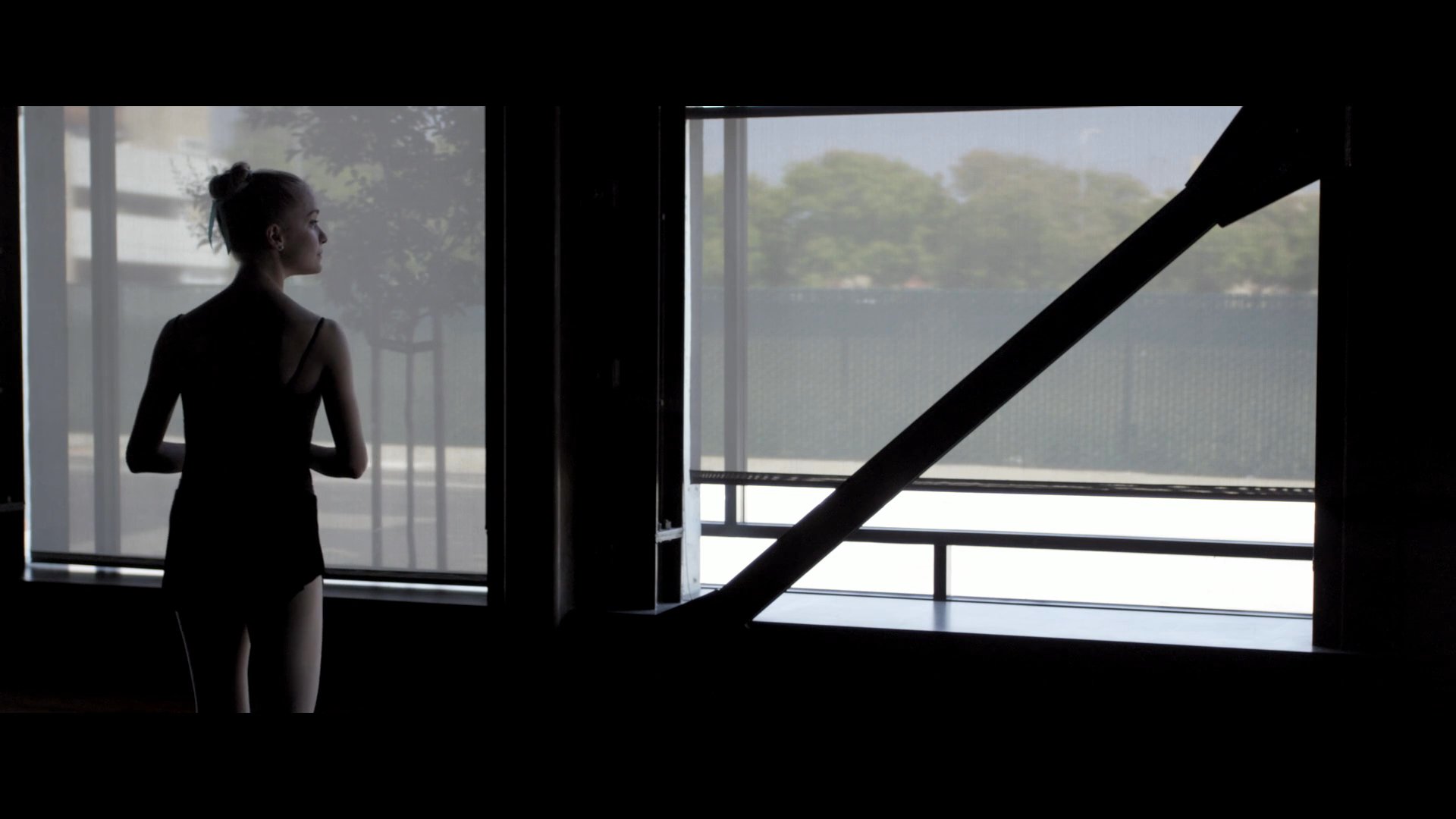 A ballerina prepares for an audition in a theatre, transitioning from a personal encounter to practicing on stage at the historic building.