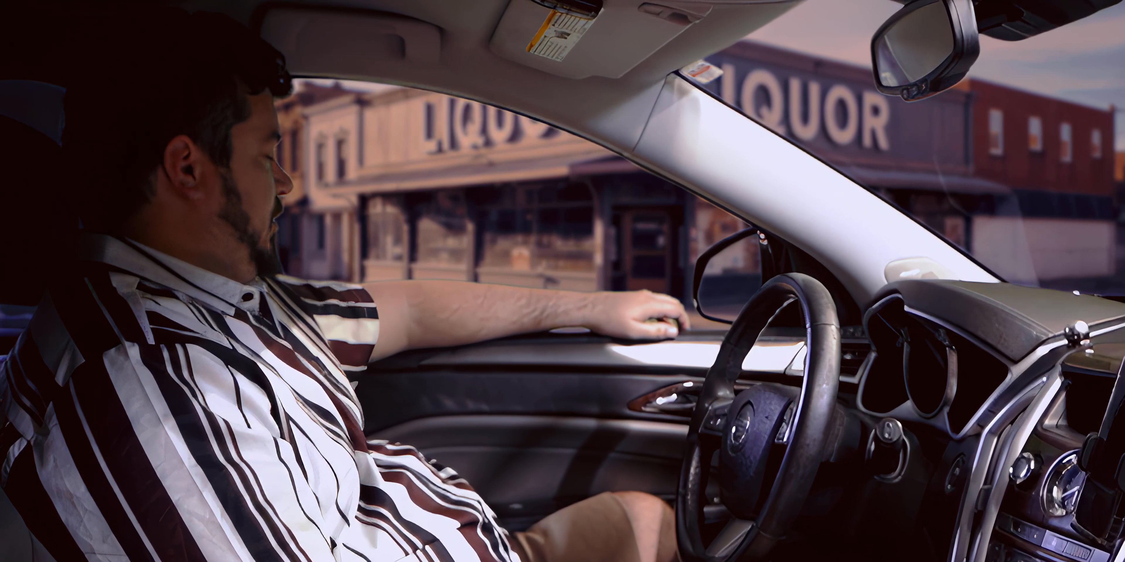 A man sits in the driver's seat of a car and observes an incoming call from Kate on his smartphone mounted to the dashboard.