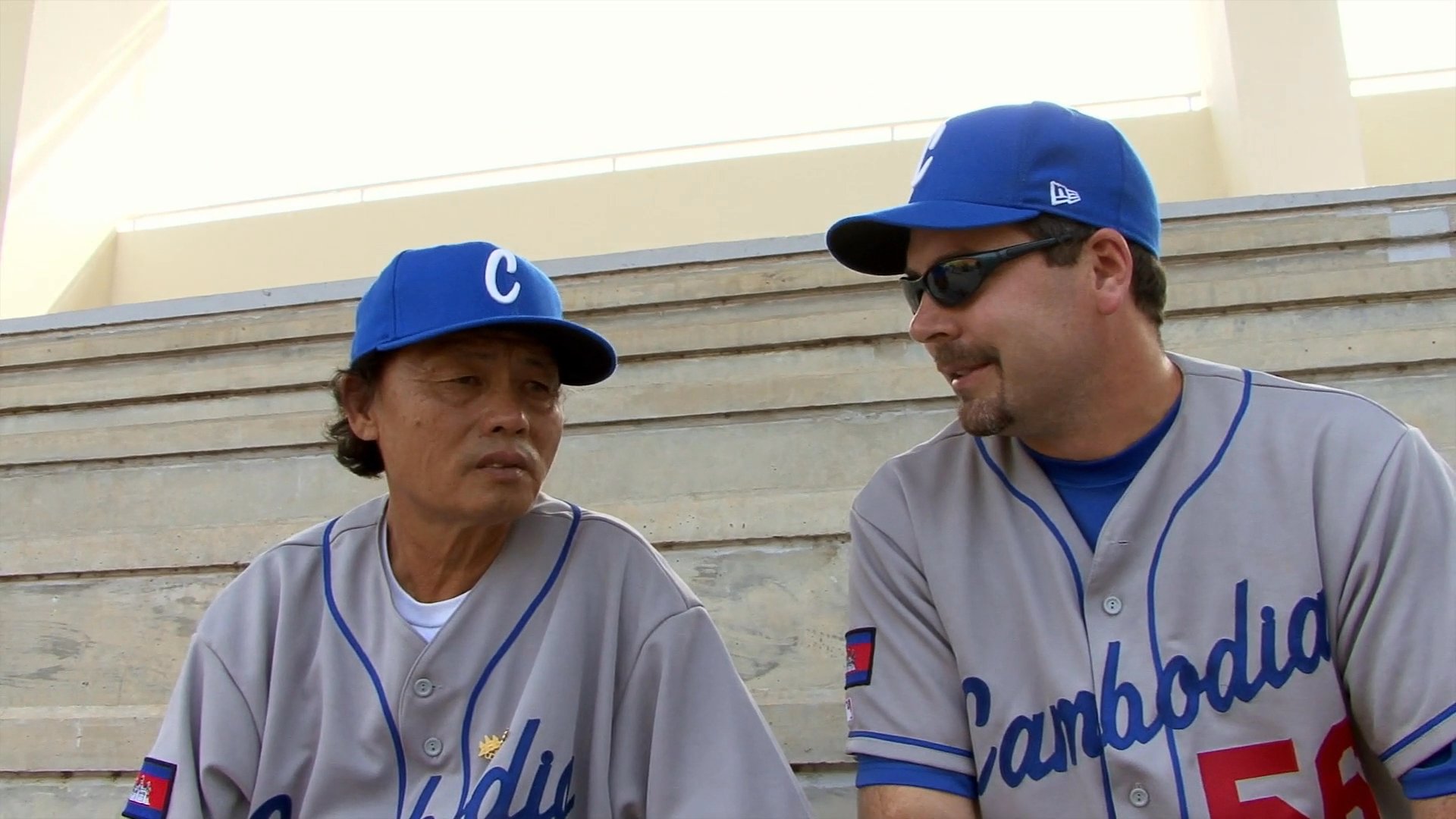 Members of a baseball team participate in on-field practice drills while coaches discuss the team's performance and challenges.