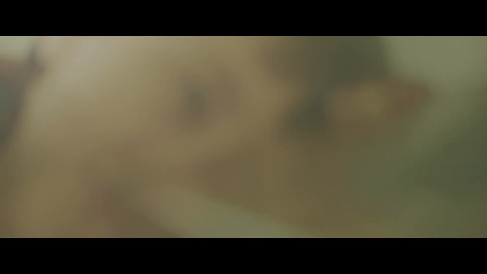 A man wakes up in his living room and engages in a playful, affectionate interaction with his young daughter. The scene captures a tender moment of family connection at home.