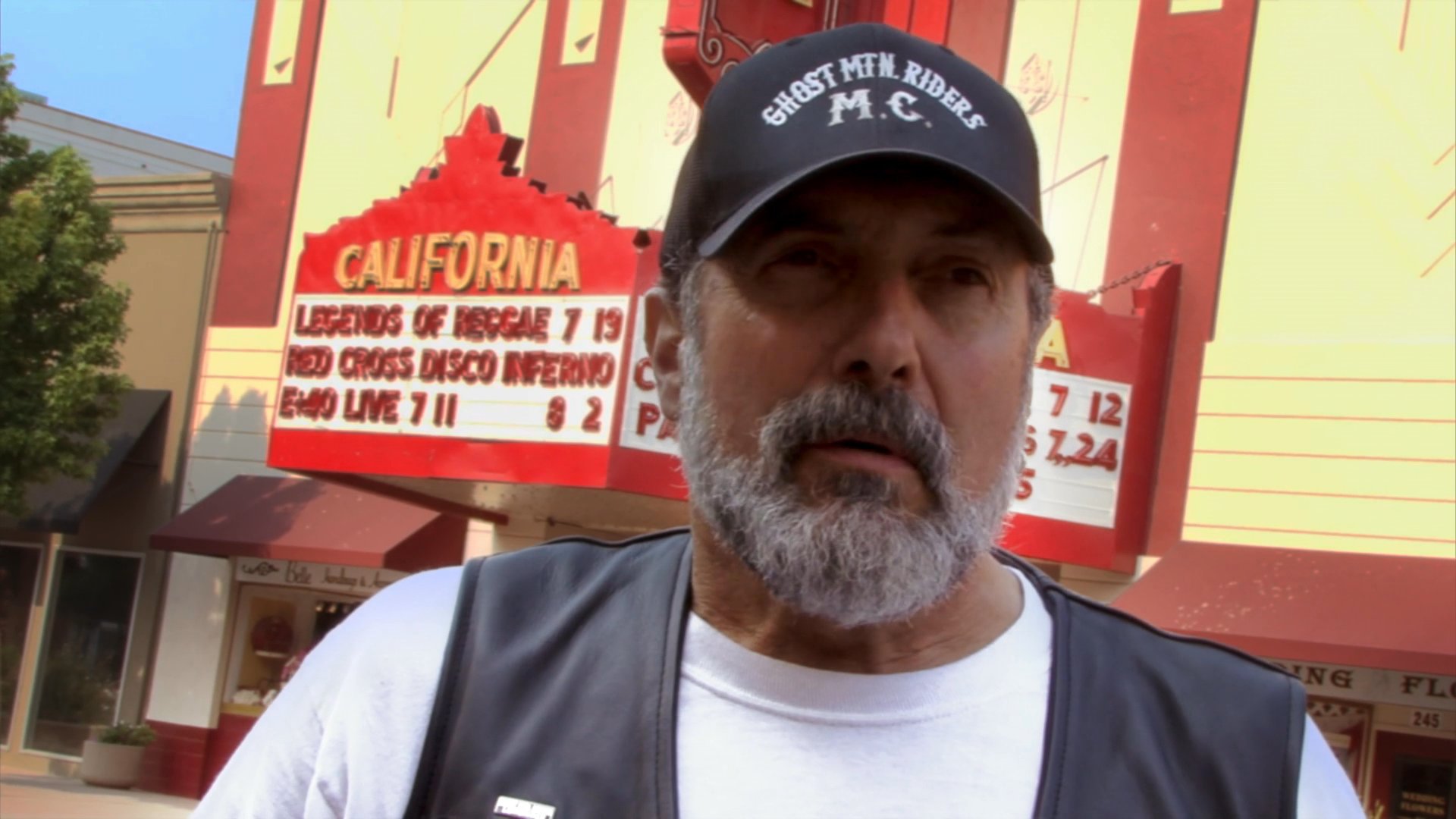 A member of a California motorcycle club provides an interview account while standing in front of a local landmark. The individual reflects on community events and shared experiences as a rider.
