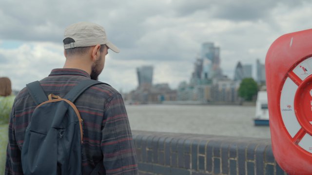 A man walks along the river in London