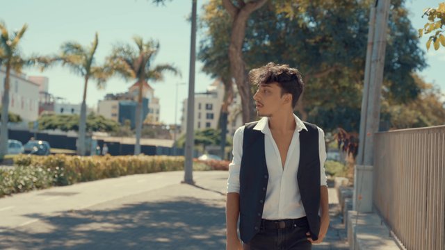 A man walks into a street and looks around confidently