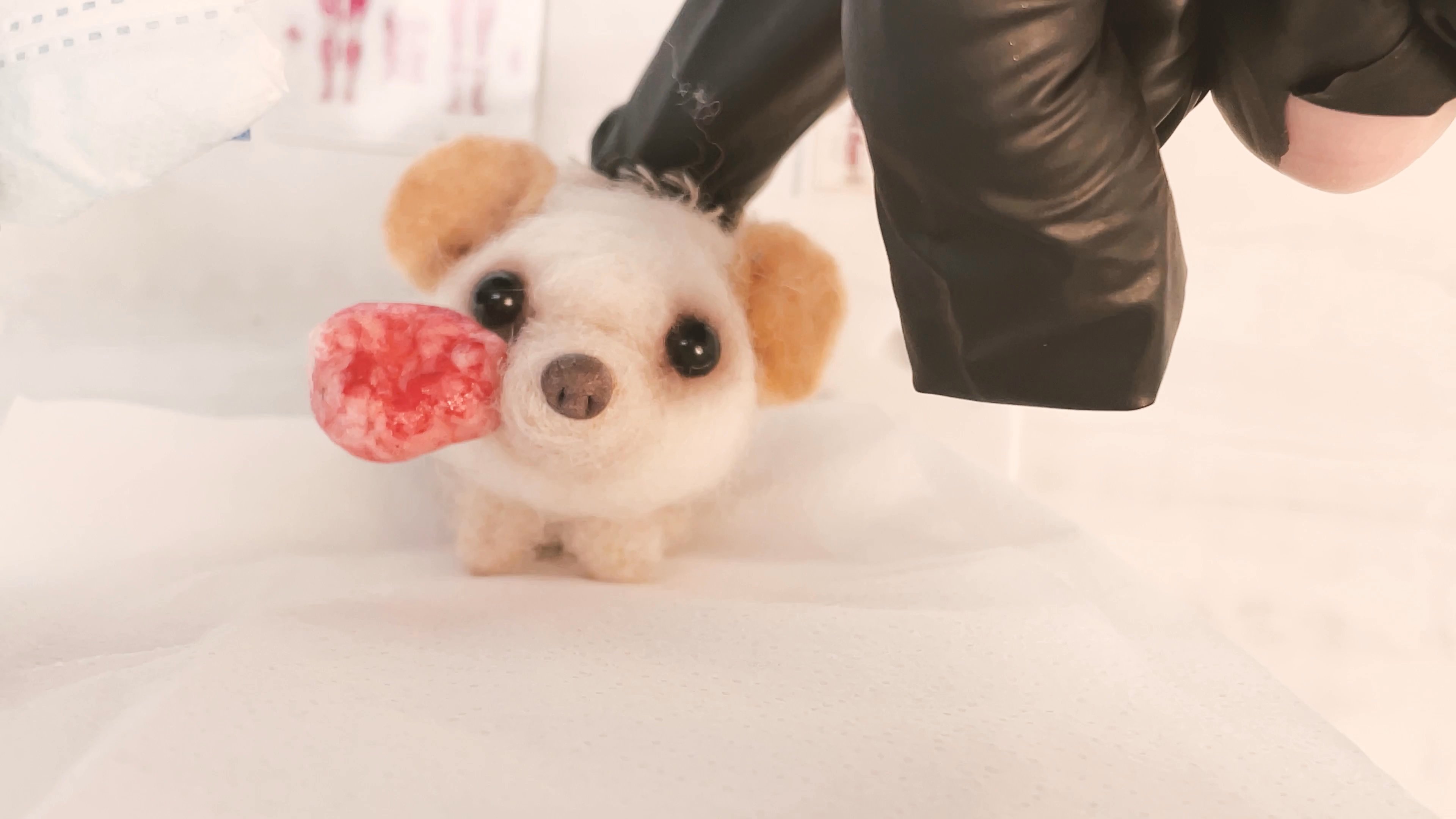 A nurse tends to a needle-felted hedgehog patient in a clinical setting, simulating a medical procedure with a mask and prop surgical tools.