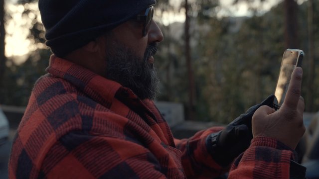 An adult man taking photos of his friend