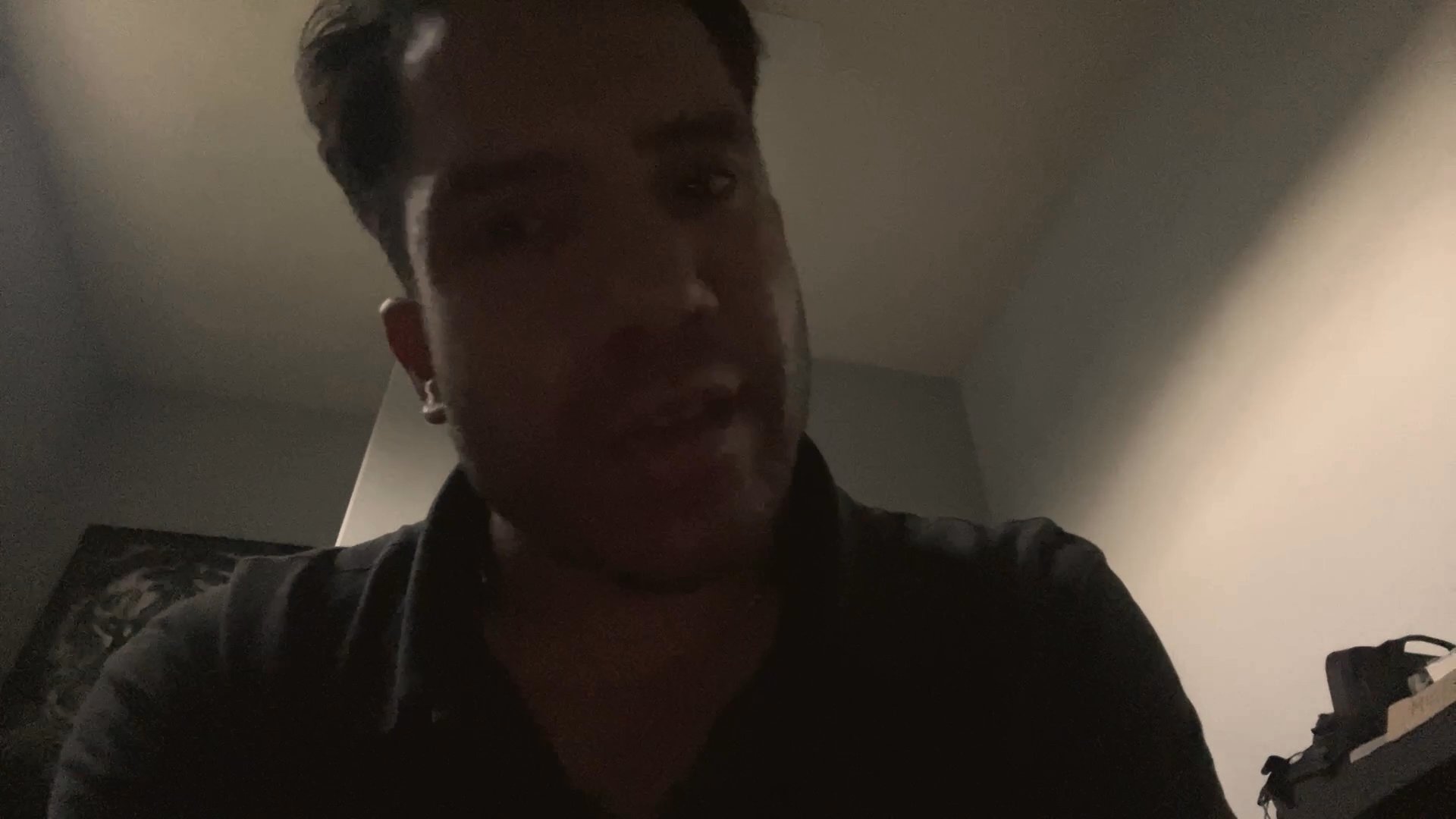 A man addresses the camera in a personal, conversational monologue, using hand gestures to emphasize his points in an interior setting.