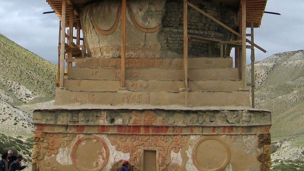 An ornate Buddhist stupa stands in a high-altitude arid landscape, showcasing intricate religious carvings and structural details. The site emphasizes traditional architectural preservation and cultural significance in the Mustang region.