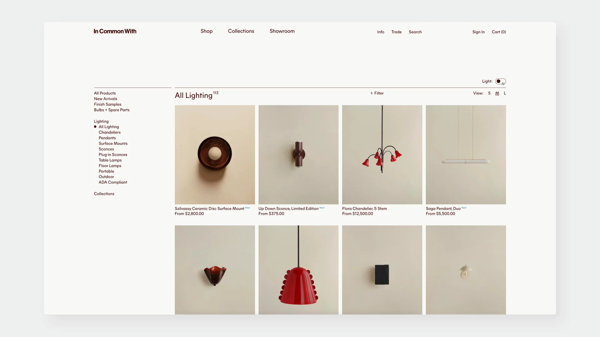 Grid of designer lighting product cards on the In Common With website, showing soft glow hover effects and animated state toggles. Each product tile displays pricing, product name, and 'New' tag on hover, with additional layout microinteractions like filter and view size controls, and a dark/light theme toggle in the top right corner—that changes the website's theme from light to dark