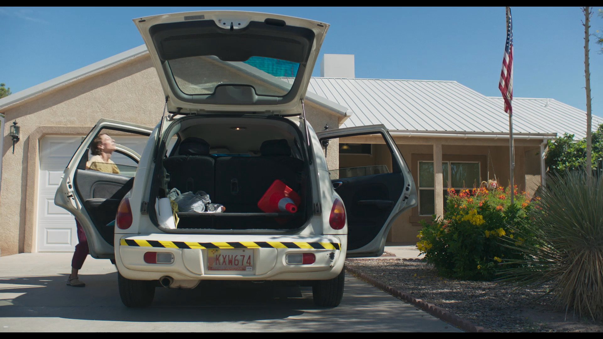 A woman retrieves a boxed air mattress from a closet and loads it into a vehicle. She subsequently unboxes the item inside a room to prepare it for use.