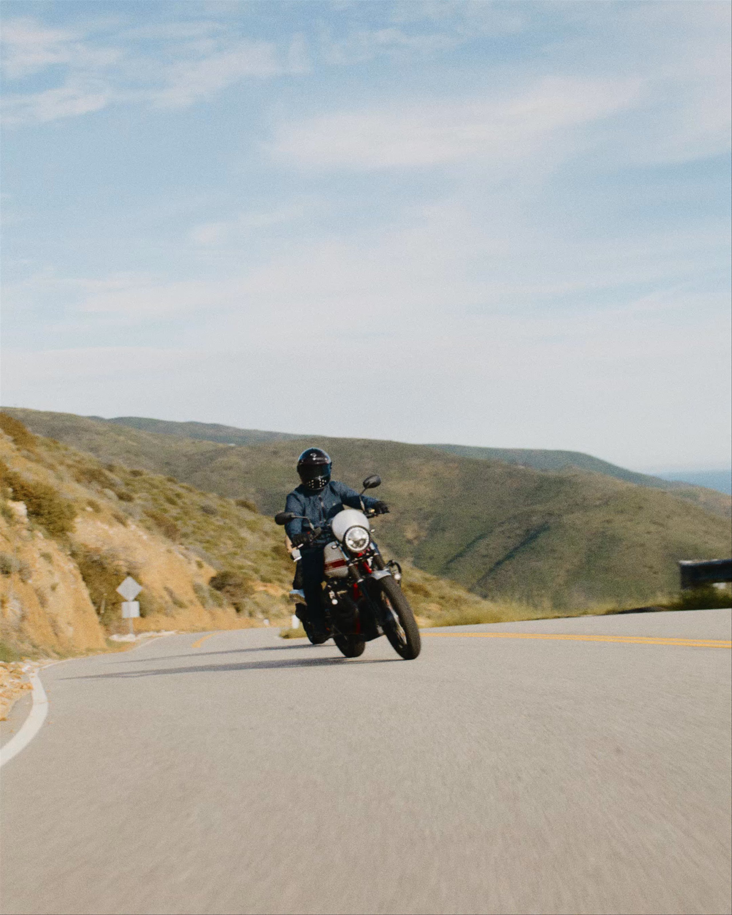 Video of two motorcyclists riding up Malibu hills with Pacific Ocean in the background
