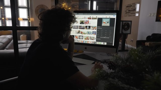 A man looking at Christmas pictures on his computer