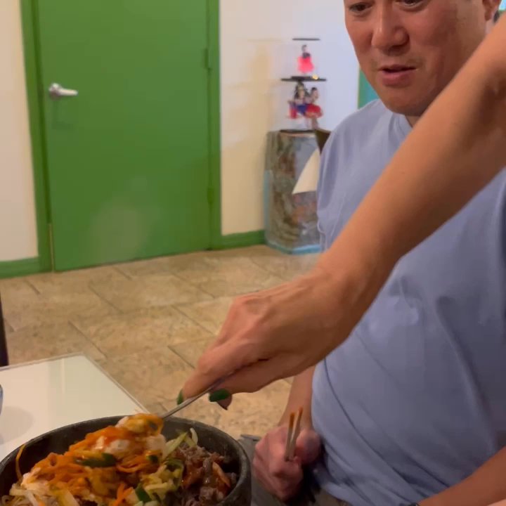 Seoul Garden - My Korean grandma mixing my friends dish with sauces she put in (rice bowl in stone ) so he could eat it the way they do. - Korean Near Me - Fort Pierce, Florida