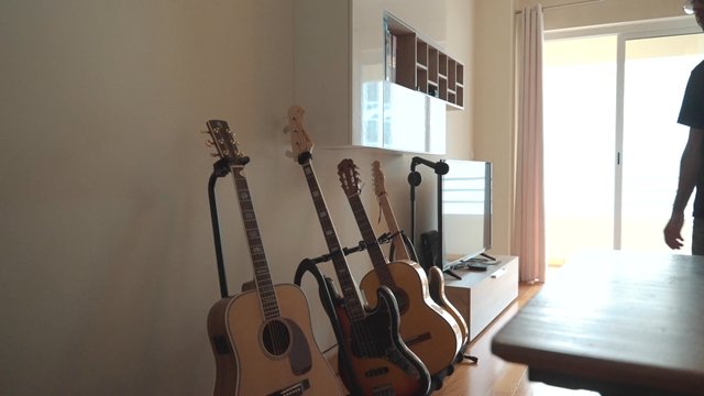 A guy picking up a guitar and preparing to play