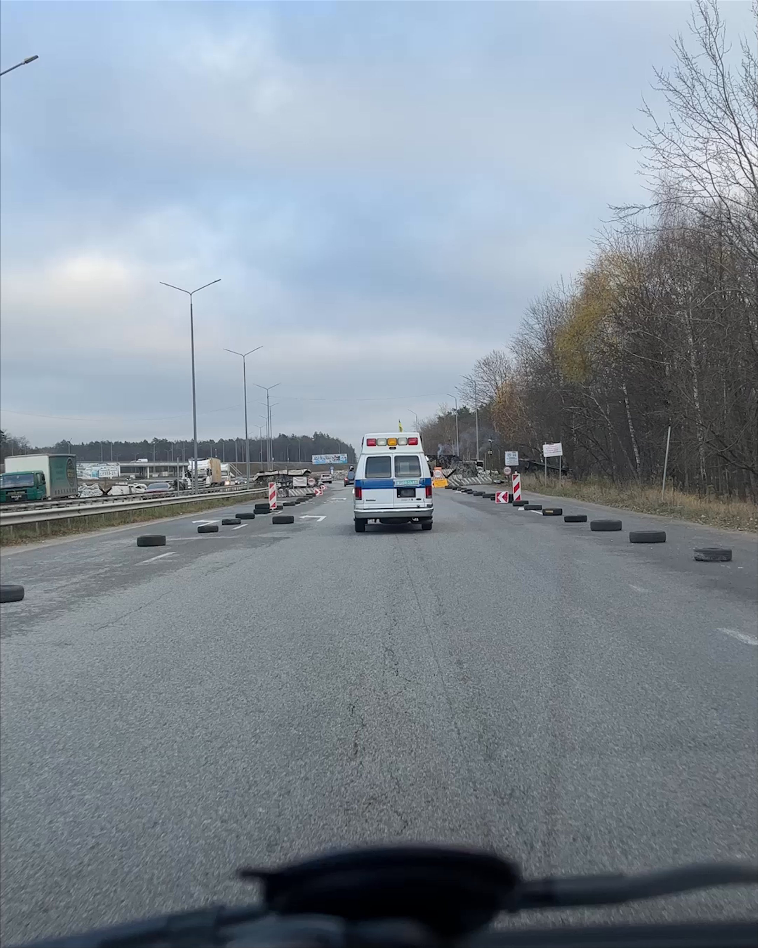 POV video of caravan of volunteer trucks driving down Ukranian highway