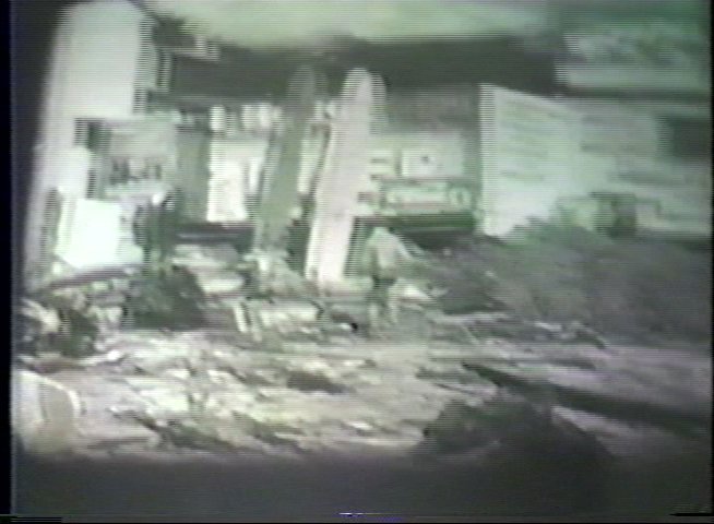 Professional footage transitions from a surfer riding a wave to archival black-and-white clips showing the aftermath of a devastating tsunami. An elderly man provides commentary, bridging contemporary surfing visuals with historical disaster imagery.
