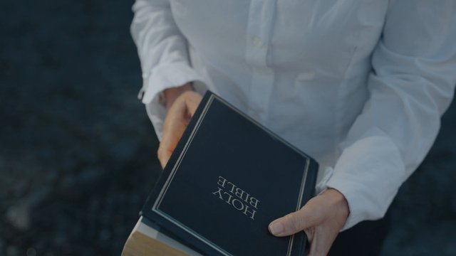 A woman closes a Holy Bible