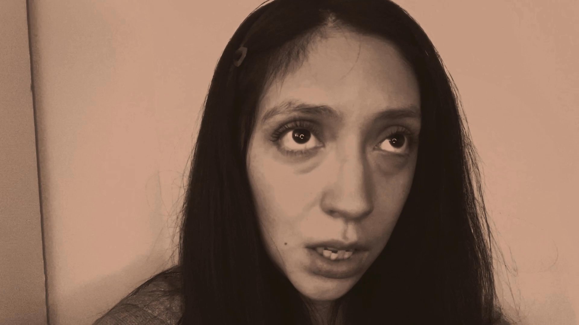 A woman delivers a poignant monologue, transitioning through various emotional expressions and shifting gazes. The performance captures a subtle narrative arc focused on internal reflection and engagement.