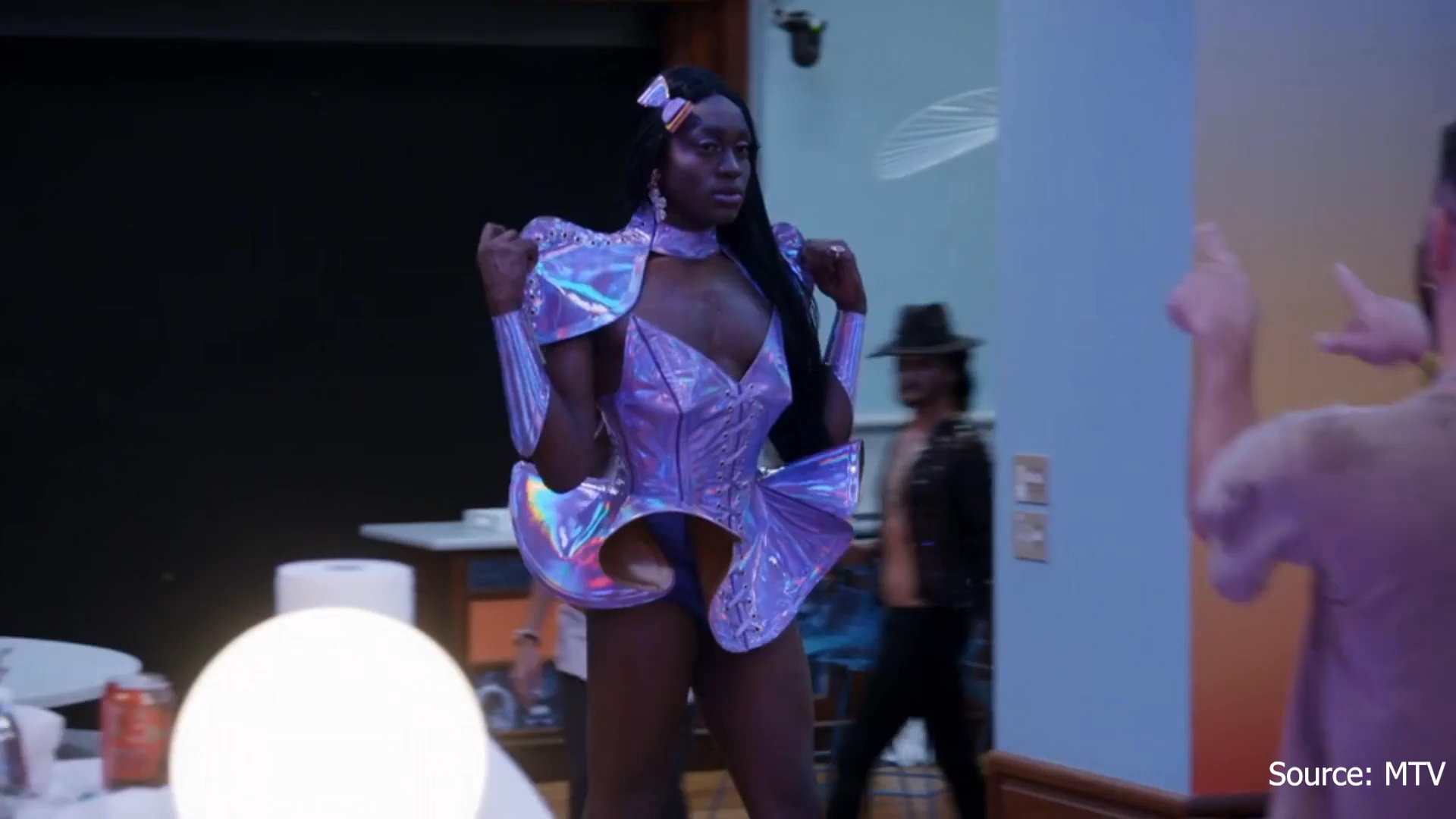 Participants in a reality television series discuss and prepare for a themed queer prom event, characterized by social festivities and individual interviews.