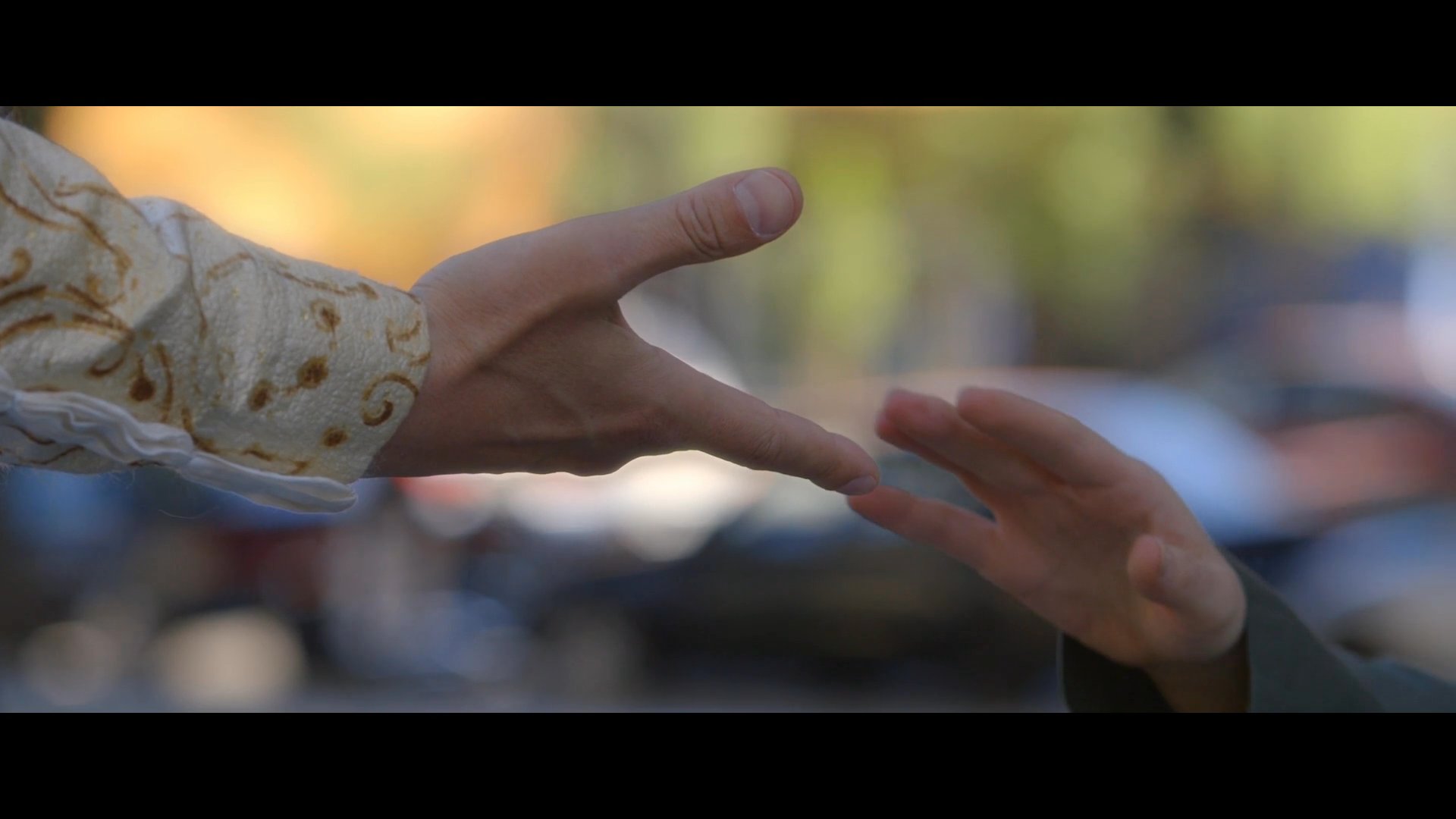 A woman experiences a profound emotional release when reunited with a figure from her past in a public park setting. The interaction culminates in a comforting embrace that bridges their separation.