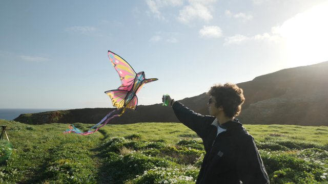 Cerrar a un chico corriendo con una cometa en el campo